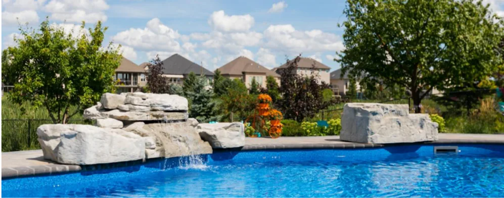 Landscaped Winnipeg backyard pool with a natural stone waterfall