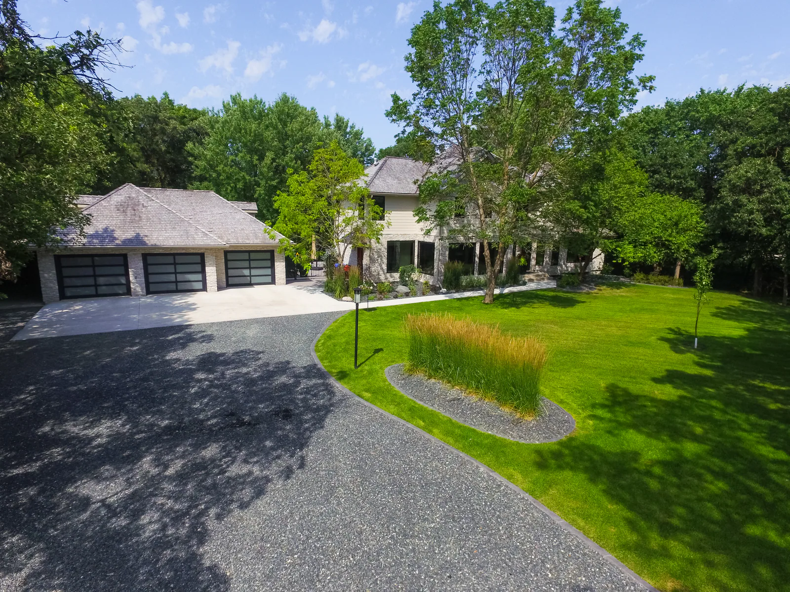 Large landscaped lawn with a curved riverstone drainage bed