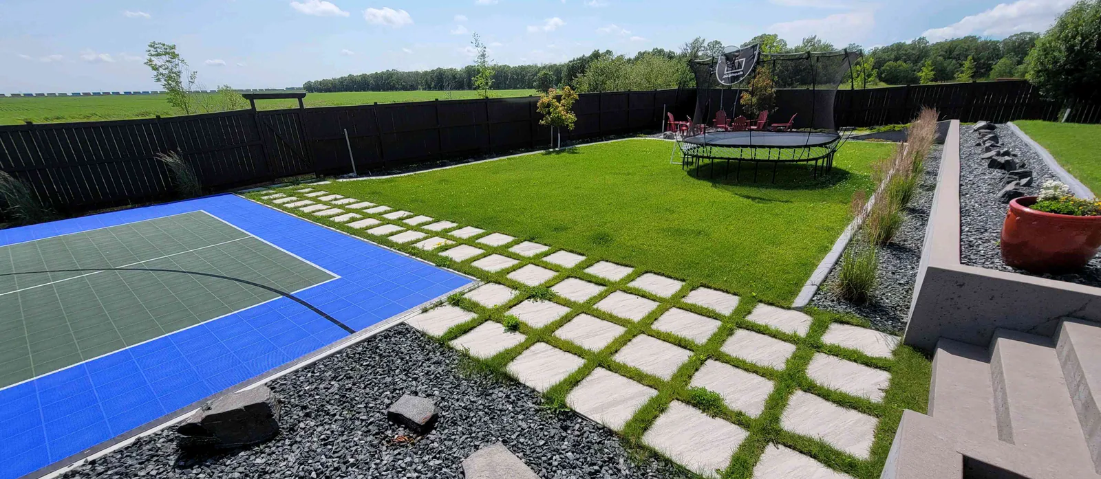 Modern backyard combining pavers, turf and decorative gravel