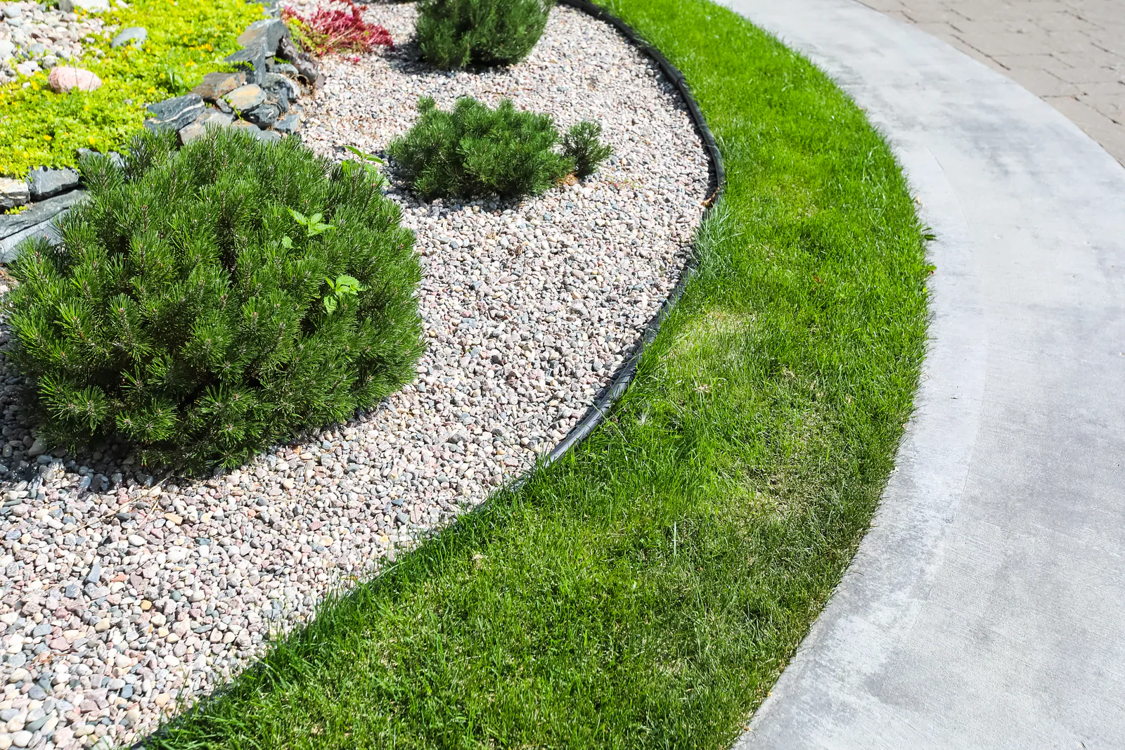 Curved decorative gravel bed beside a green lawn