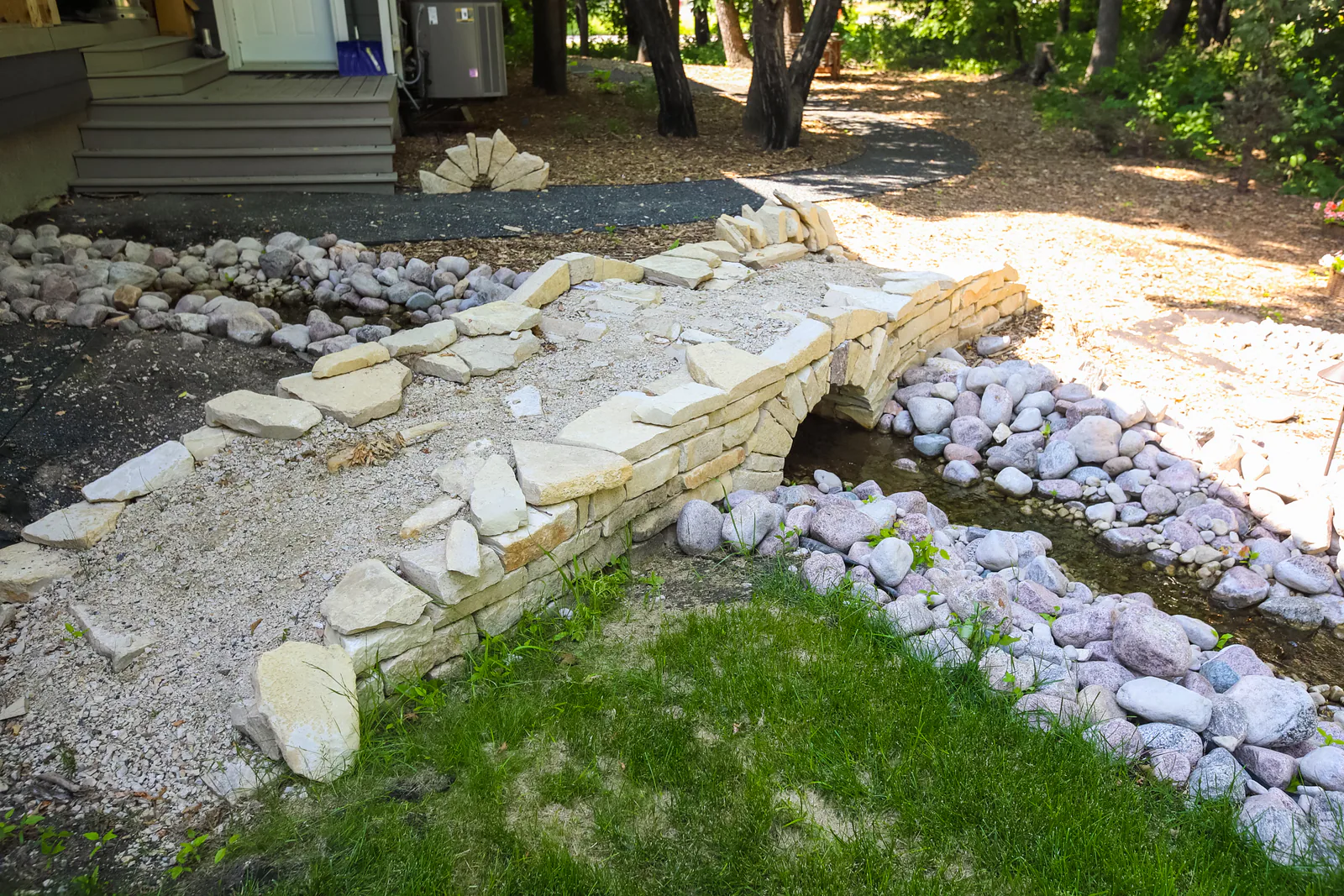 Stacked stone retaining wall with a river rock drainage bed