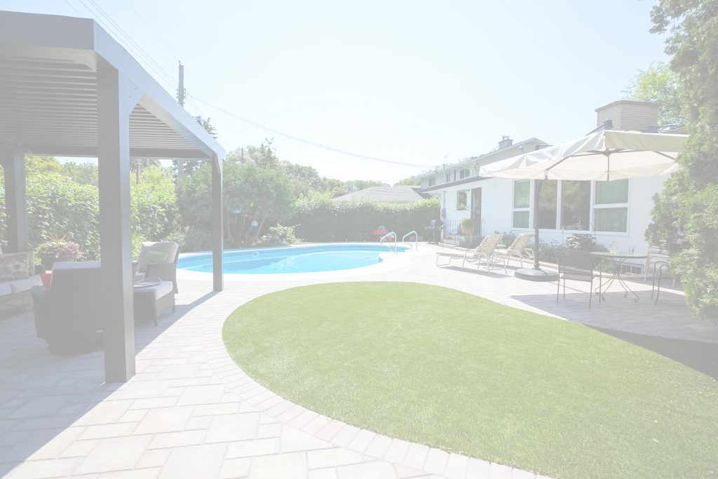 Backyard pool beside artificial turf and a paved patio
